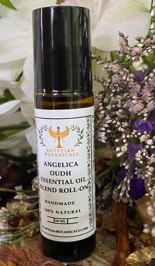 Essential oil roll-on bottle with a label Angelica oudh natural botanical perfumeagainst a floral background