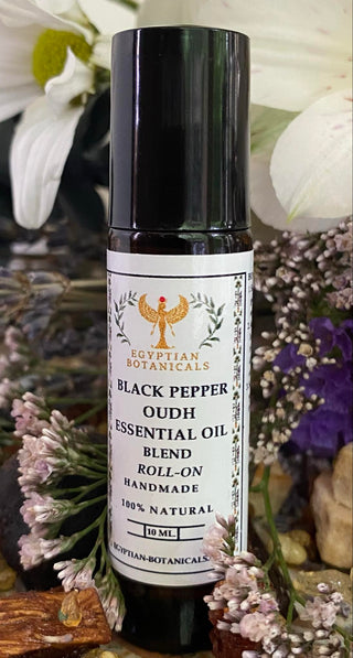 Black Pepper Oudh Essential Oil Blend roll-on bottle with Egyptian Botanicals branding against a floral background.