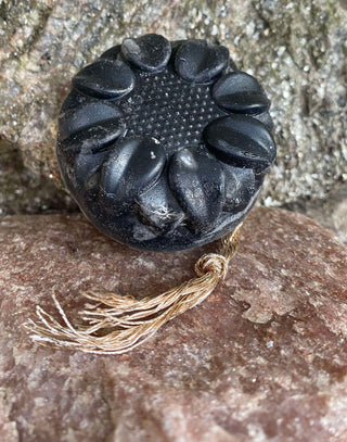 Charcoal and Loofah Foot Scrub Soap Bar leaning against a rock
