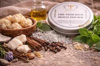 Tin of 'Like Tiger Balm Muscle Pain Rub' surrounded by ingredients on a wooden surface