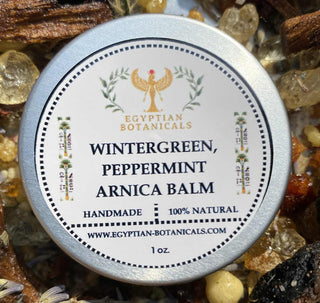 Balm container labeled 'Wintergreen, Peppermint Arnica Balm' by Egyptian Botanicals on a natural product background.