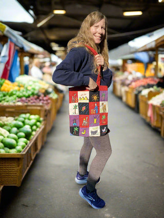 Person holding a colorful tote bag in a market setting